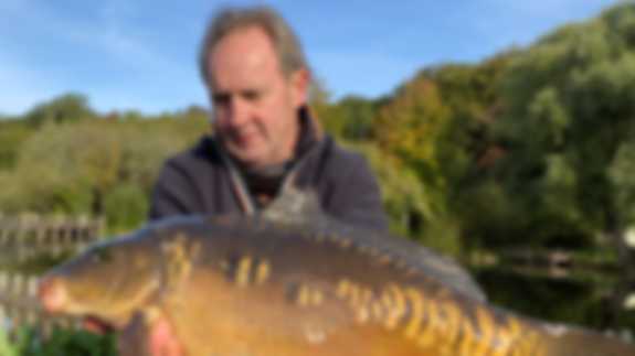 A person holding a caught fish on a sunny day