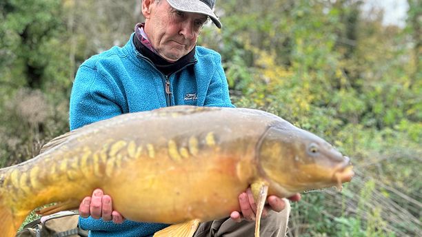 A fisherman poses with a Mirror fish.