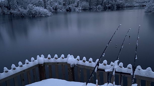 A snowy lake scene with fishing rods set up and ready to go