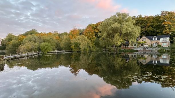 A view of the house with the lake in the foreground